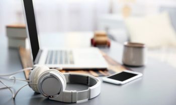 Headphones sitting next to a laptop on a legal transcriptionist's desk.