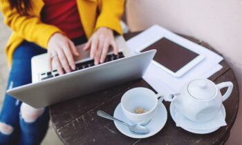 A freelancer working a gig job from a laptop at a cafe.