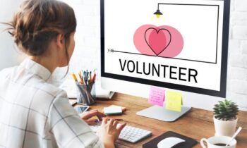 A woman volunteering virtually from a computer in her home office.