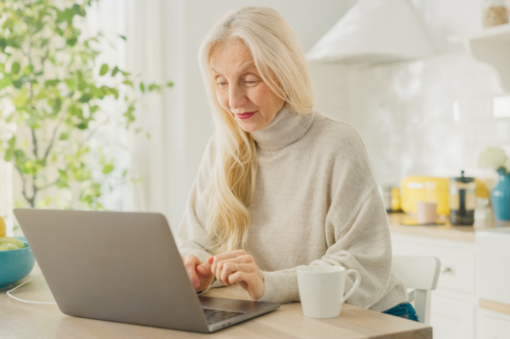 A female retiree earning extra money from home on laptop