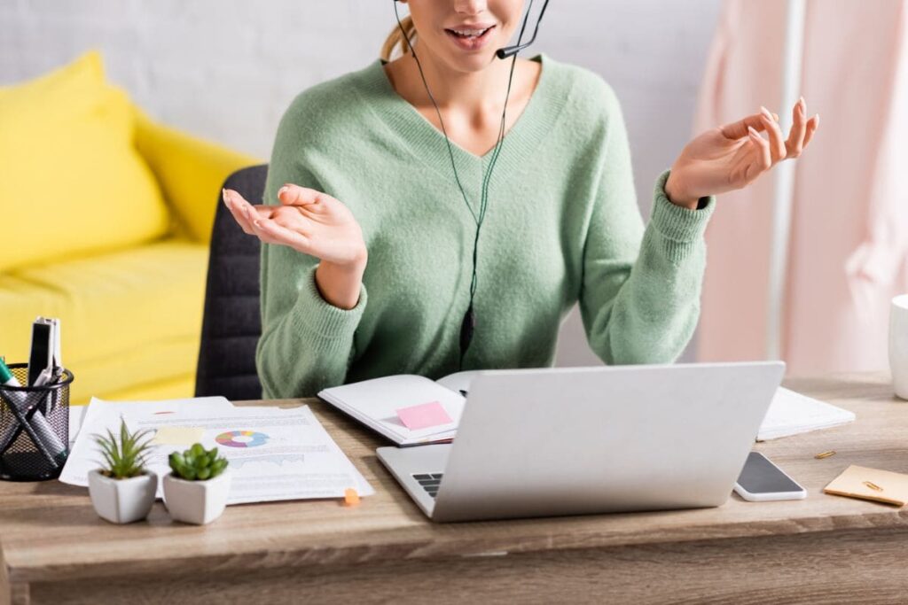 An American Express work from home employee, using a laptop and headset from her home office.