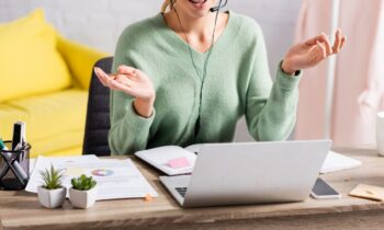 An American Express work from home employee, using a laptop and headset from her home office.