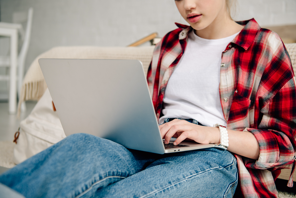 Female teen making money from home on her laptop