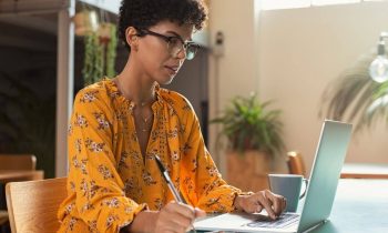 SEO specialist working from home on her laptop and taking notes