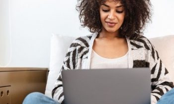 Woman writing on laptop at home.