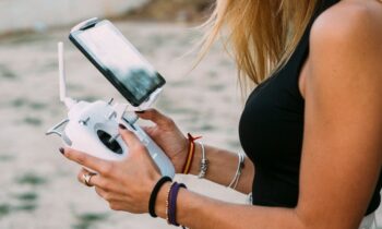 A close up image of a woman holding a drone remote.