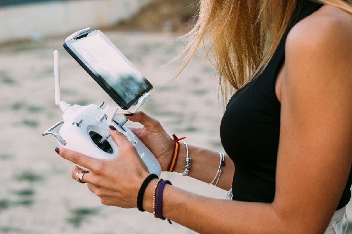 A close up image of a woman holding a drone remote.