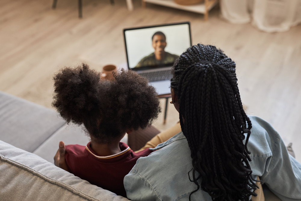 Military spouse and daughter having a video call with their loved one