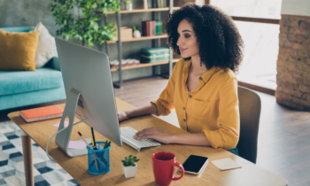 Pretty young lady working from home at desk on her insurance jobs