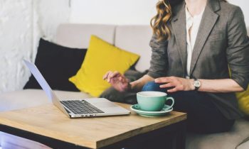 Woman working from home on a laptop, drinking coffee