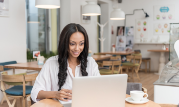 woman working in a cafe testing websites for cash