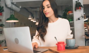 Woman working on her laptop in a coffee shop