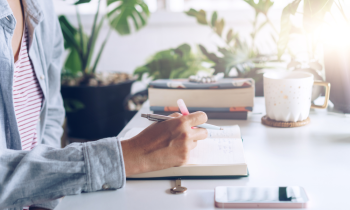 woman writing in her notebook figuring out ways to make an extra $2,000 per month