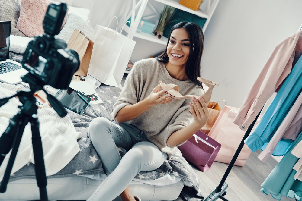 Young woman unboxing shoes for a social media video