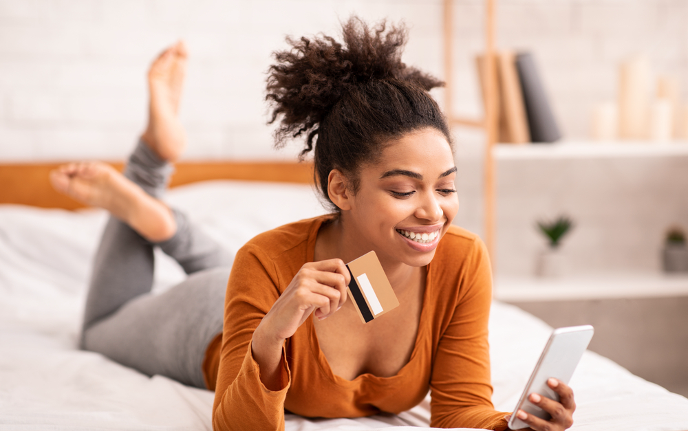 Young woman using her smartphone to earn free Amazon gift cards online